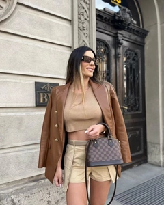 Detail of dark brown faux leather blazer paired with a chic knit halter top for women