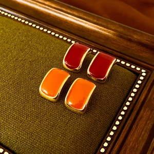 Vintage small square enamel stud earrings in dark red and bright orange with gold base