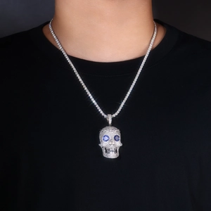 Detailed view of large S925 silver skull pendant with blue gem eyes on tennis chain