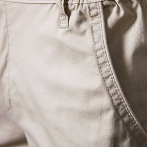 Detailed macro view of khaki cotton twill shorts showing waist seams and side pockets