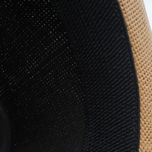 Detail shot of woven straw hat featuring black sweatband and breathable mesh lining inside