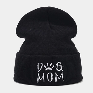 Nahaufnahme der Dog Mom Bestickung und Pfotenabdruck auf einer schwarzen Strickmütze