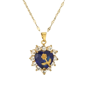 Golden heart necklace with deep blue gemstone and rose detail on white background