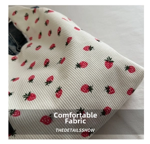 Detail of strawberry print on white ribbed texture canvas tote bag with denim lining