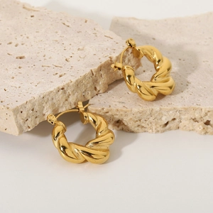 Detailed view of gold plated stainless steel twisted hoop earrings on stone