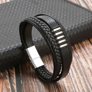 Detail of multi-layer black braided leather bracelet with silver magnetic buckle