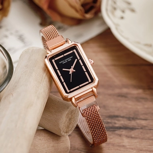 Retro rose gold square watch with black dial and Milanese mesh strap on vintage background