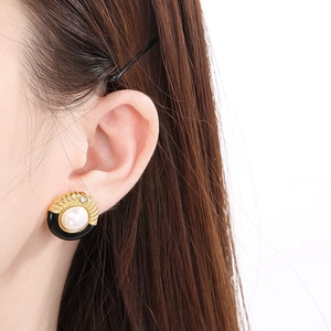 Gros plan de boucles d'oreilles rondes vintage avec texture dorée et nacre de perle
