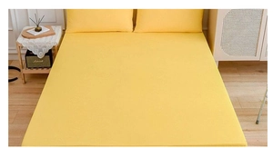 Detail view of bright yellow bedding set with smooth fabric texture in a cozy bedroom
