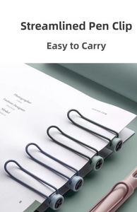 Détail de clips métalliques profilés sur des stylos colorés fixés à un carnet