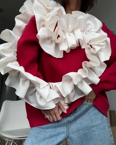 Détail du sweat-shirt rouge avec patchwork de cœur à volants blancs sur le devant