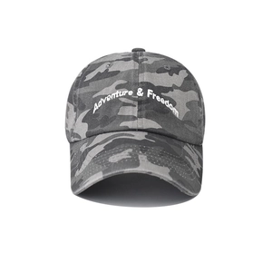 Close-up of Adventure & Freedom white embroidery on a washed camouflage tactical baseball cap