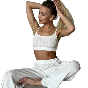 White two-piece loungewear set with crop camisole and wide-leg knit pants with frill hem