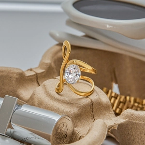 Macro detail of a 18K gold-plated titanium ring with an oval zircon on curved lines