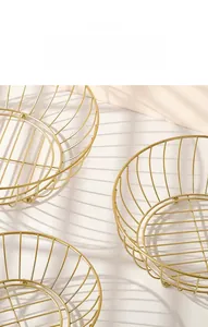Detail showing stackable golden iron fruit baskets with hollow wire design and plating