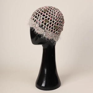 Détail du bonnet au crochet blanc cassé avec paillettes et bordure en fausse fourrure