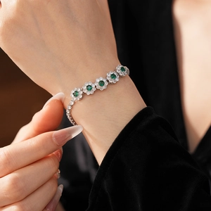 Détail du bracelet floral en zircon avec pierres émeraude porté au poignet