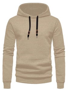 Detail of khaki waffle textured hoodie fabric with black drawstrings and brown toggles
