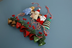 Detail of handmade crochet Santa, reindeer, and Christmas tree charms with festive bells