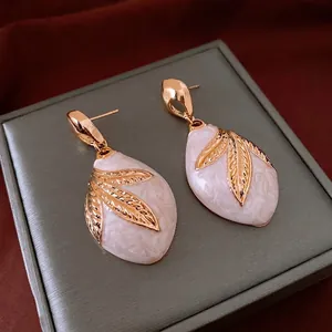 Vintage gold leaf drop earrings with white marble enamel in a luxury jewelry gift box