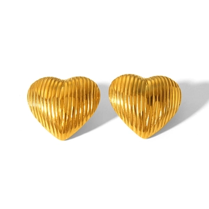 Close-up of heart-shaped gold earrings featuring fine vertical striped texture details