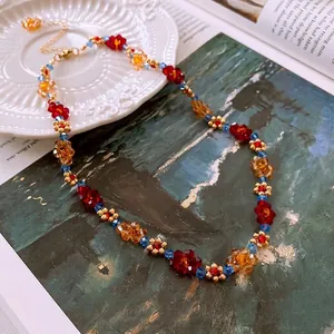 Collier artisanal perlé avec cristaux colorés et billes de séparation dorées