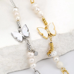 Detail of 14K gold butterfly pendant with pearls and metallic beads on stone