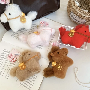 Dettaglio di portachiavi a forma di pony in peluche con lingotti d'oro e ganci