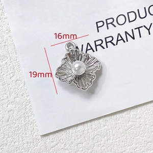 Pendentif fleur argenté avec perle blanche et détails des dimensions de 16x19mm