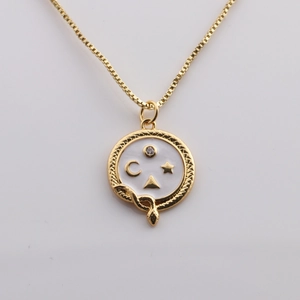 Gold box chain necklace with white enamel round pendant featuring stars and moon motifs