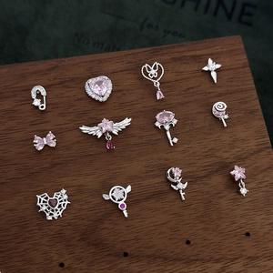 Macro detail of pink zircon heart and butterfly bow stud earrings on wooden display