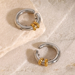 Minimalist stainless steel hoop earrings with gold accents and industrial design style