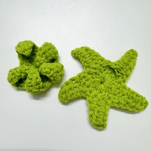 Handmade crochet accessories featuring grass green starfish and flower shapes in yarn