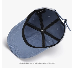 Detail of adjustable strap and reinforced inner stitching on distressed denim baseball cap