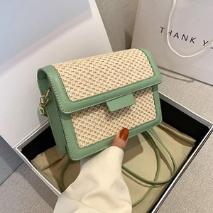 Detailed view of mint green straw tote bag inside gift box with shoulder strap