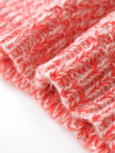 Macro view of soft red and white mixed knit fabric showing plush wool texture and weave