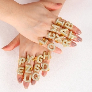 Detailed shot of 18k gold plated chunky bubble letter rings with zircon micro-pave