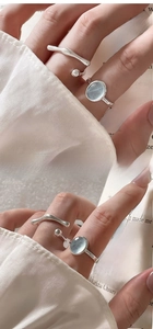 Detail of stacked S925 silver rings with blue gemstone and minimalist wave designs