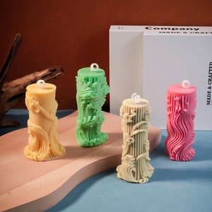 Detailopname van kleurrijke cilindrische kaarsen met 3D reliëf en bloemmotieven