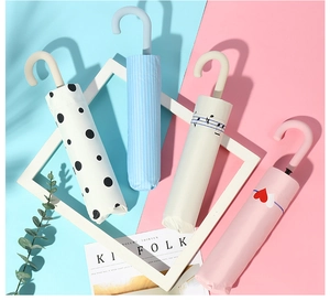 Foldable sun umbrella detail featuring polka dot, stripe, note and heart pattern designs
