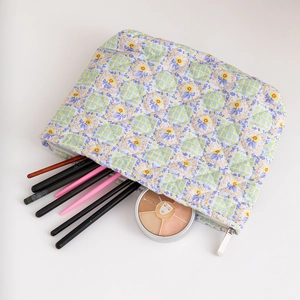 Quilted floral makeup bag with blue and yellow flower pattern and metal zipper