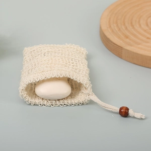 Macro view of mesh soap foaming pouch with a natural cotton drawstring and wooden bead