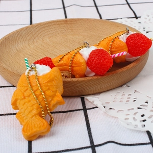 Handmade strawberry taiyaki fish-shaped cake keychains with cream on a wooden tray