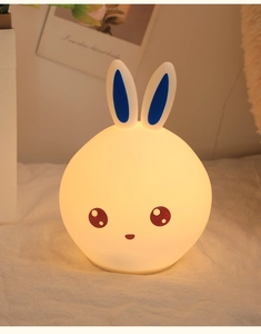 Close-up of soft white silicone rabbit night light emitting warm glow in a cozy bedroom