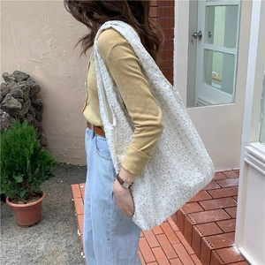 Close-up of white floral lace canvas tote bag with intricate cutout texture outdoors