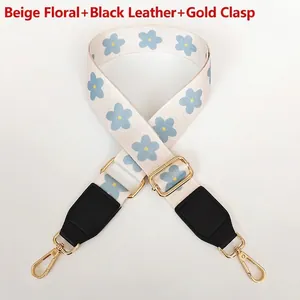 Detail of adjustable floral bag strap with blue flowers and golden metal hooks
