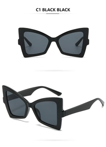 Detail view of butterfly cat eye sunglasses in black plastic frame with dark lenses