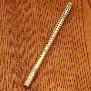 Macro detail of golden metal pen with Monkey King staff design and cloud engravings