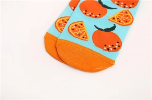 Détail de chaussettes en coton bleu avec motifs orange et pointe de pied contrastée