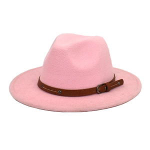 Close-up of pink fedora hat with brown leather band and metal rivets detail